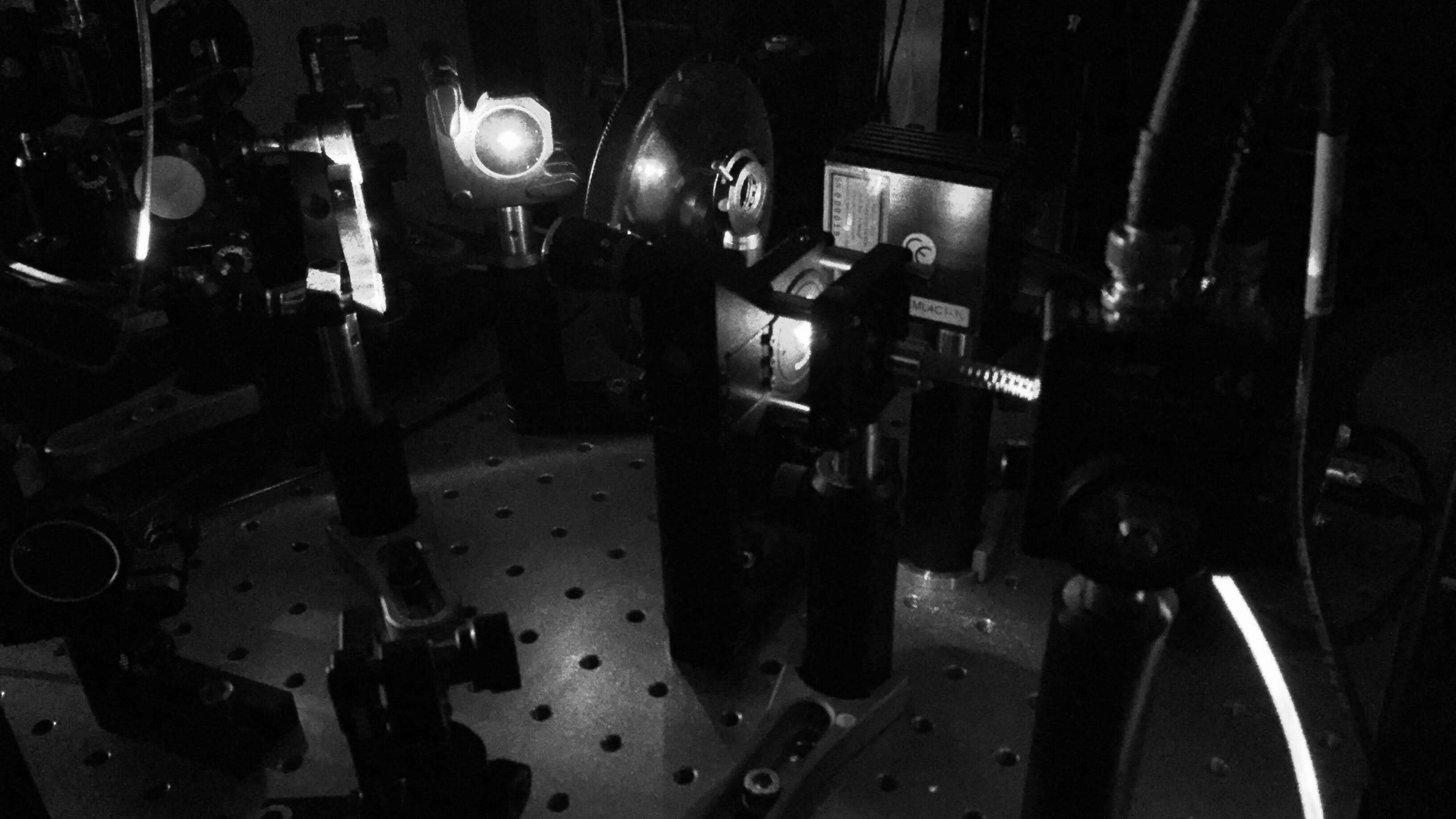 laser light scattering across an optical table in a darkened room